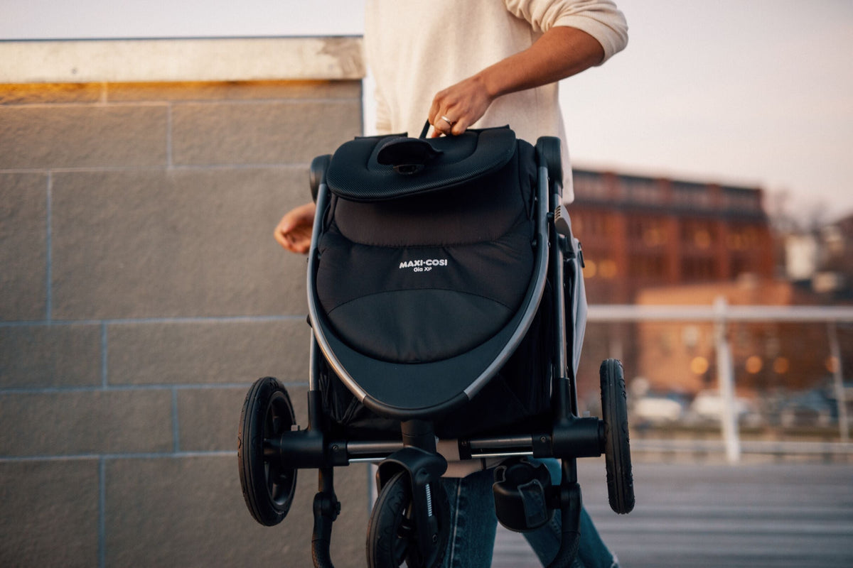 father carrying folded Gia stroller