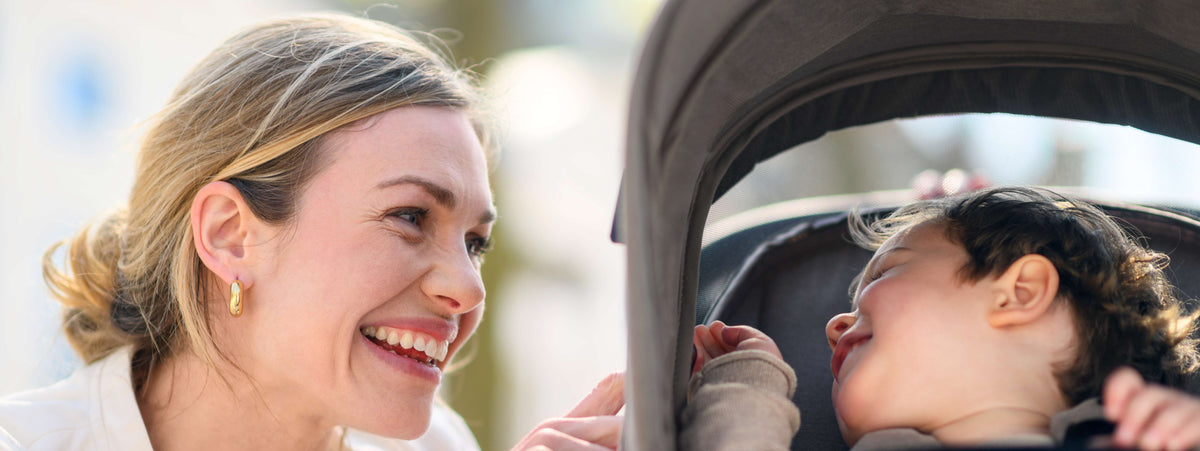 mother smiling at child in stroller