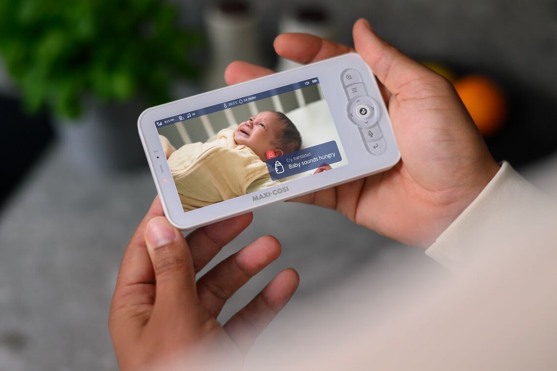 Parent looking at baby monitor that says Baby Is Hungry
