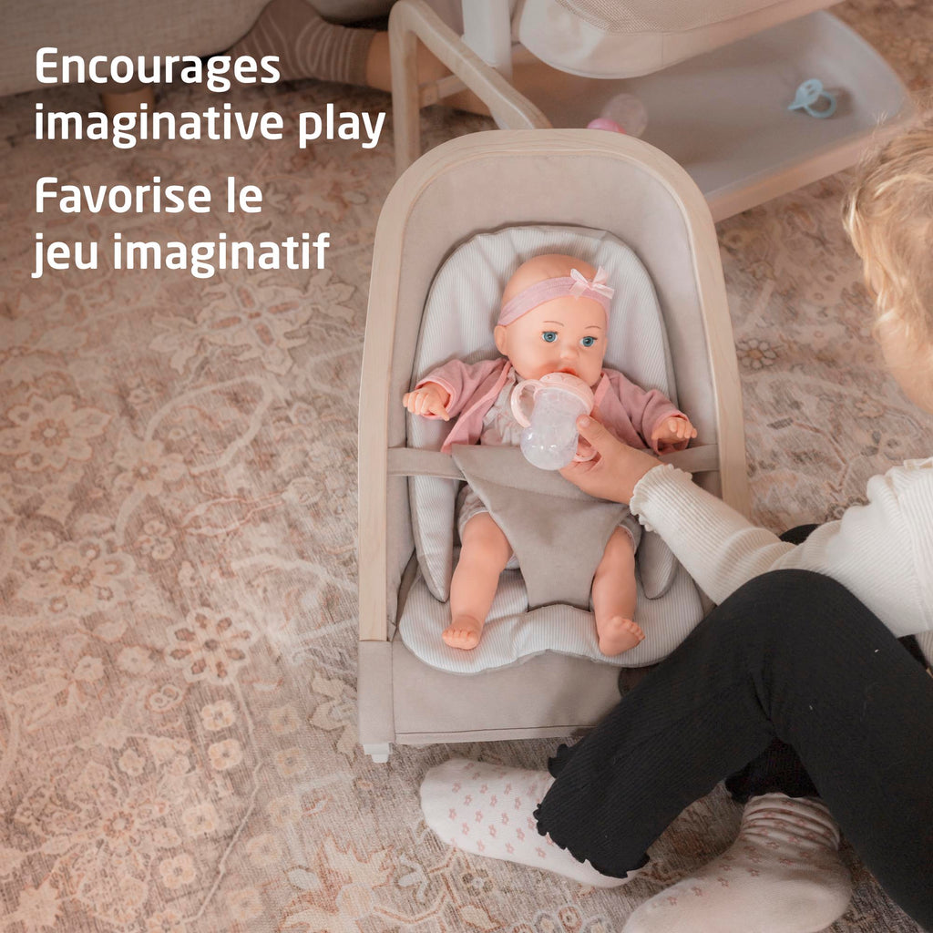 Overhead angle of a toddler caring for her baby doll in the Maxi-Cosi Kori Doll Rocker, encouraging imaginative and nurturing play.
