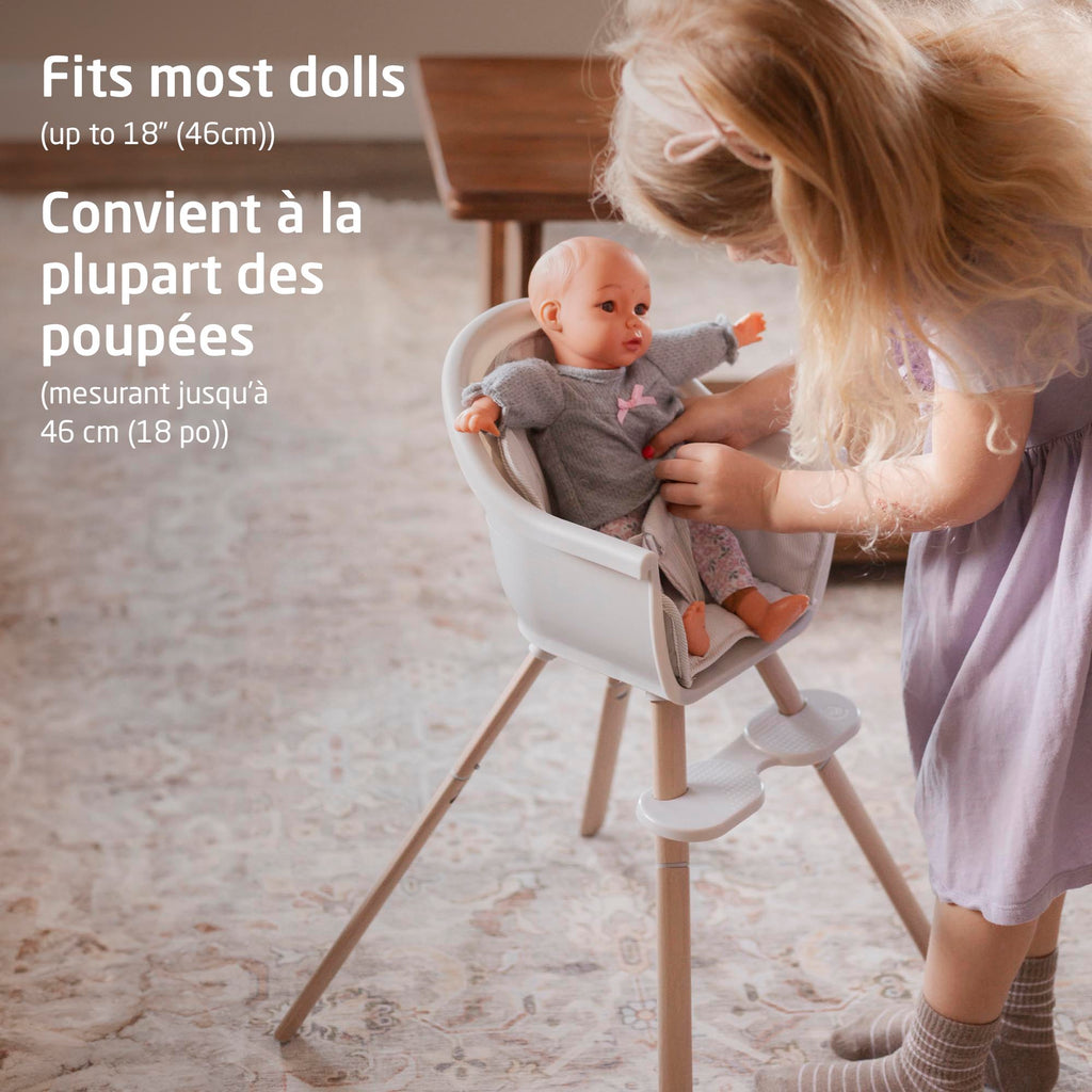 Child standing beside the Maxi-Cosi Moa doll high chair fitting dolls up to 18 inches (46 cm).