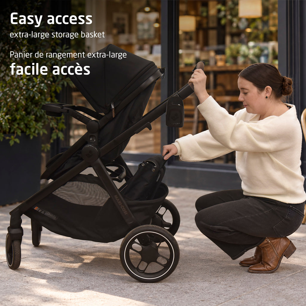 Parent easily accessing baby gear inside the extra-large under-seat storage basket of the Zelia Pro stroller.